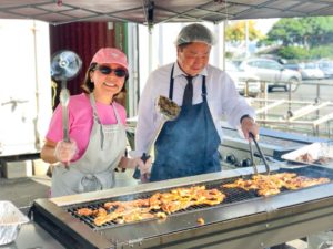 Rev. Nishiyama in apron barbecuing chicken